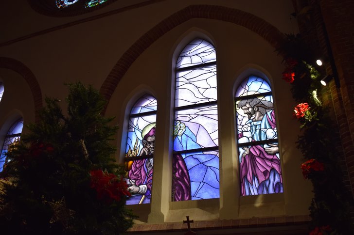 Het linker glas-in-loodraam representeert de heilige Augustinus, de rechter de Goede Herder