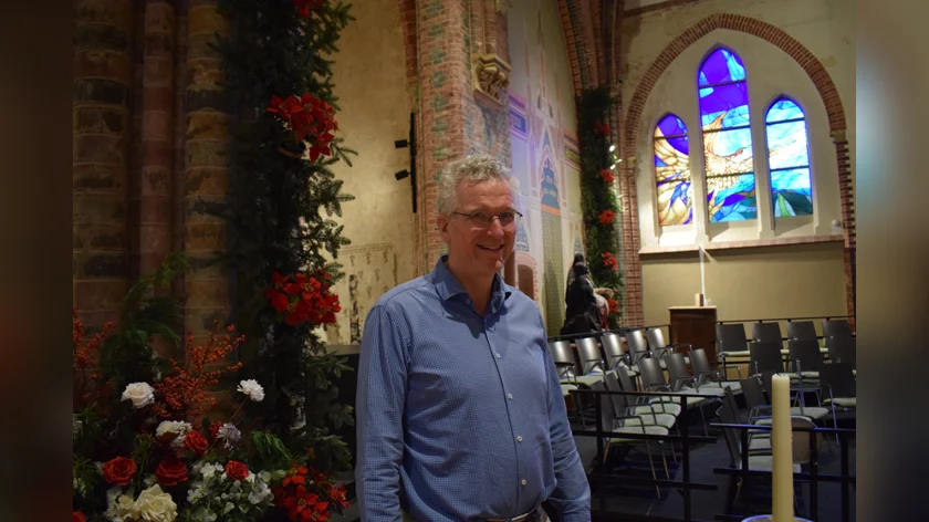 Jeroen Potjes met op de achtergrond het glas-in-lood van de feniks Foto: Julia Hensbergen